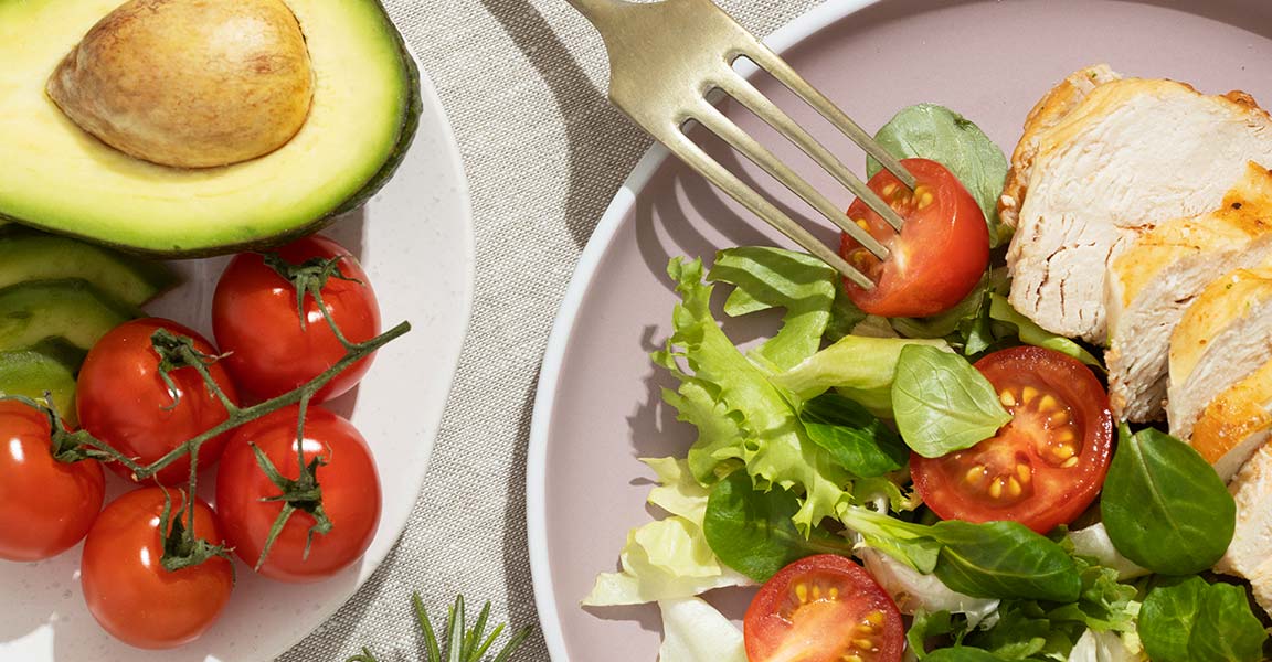Fotografía de comida saludable: pollo, espinacas, lechuga, tomates, aguacate.